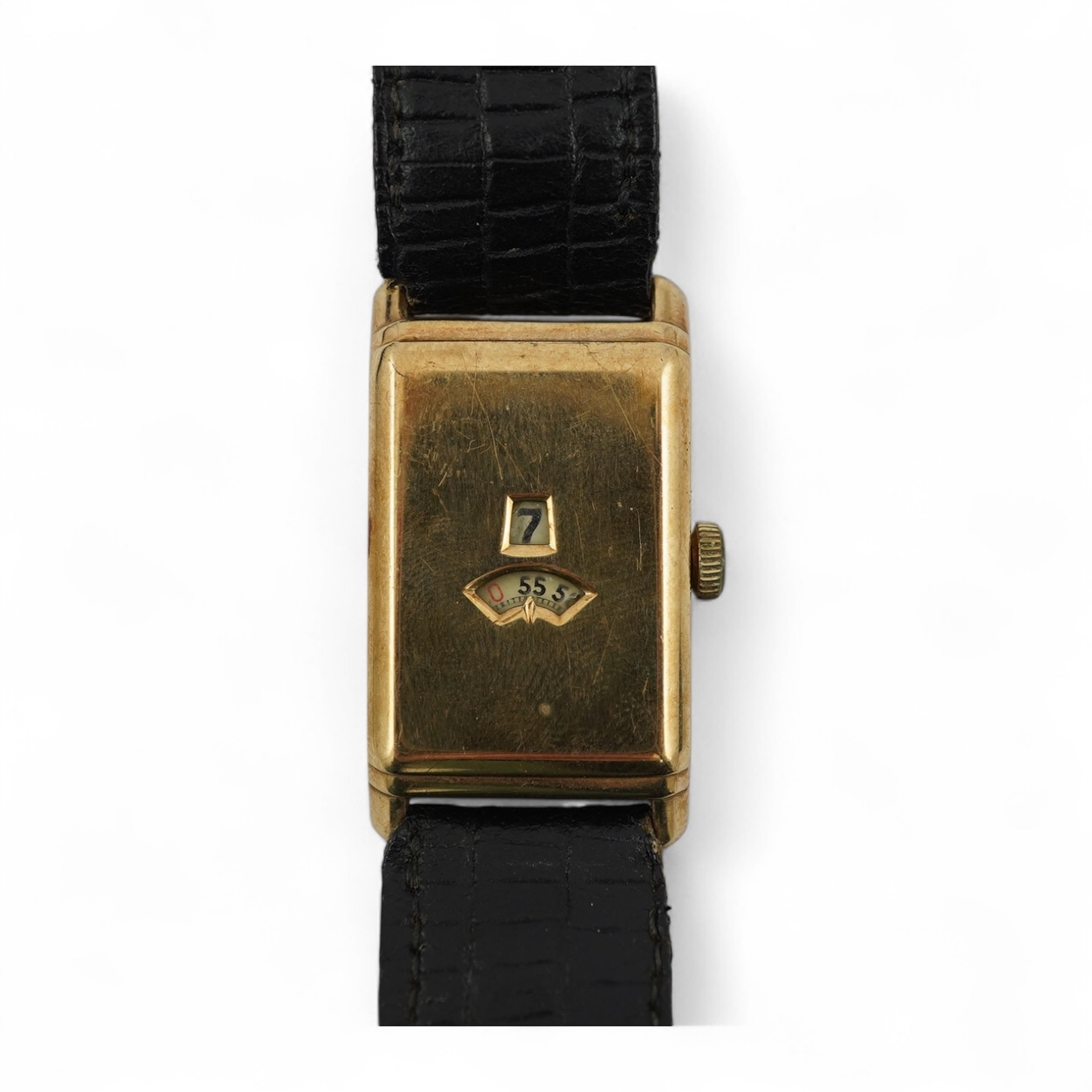 An early 1930's 9ct gold Swiss 'Jump Hour' rectangular cased manual wind wrist watch, case diameter 20mm, on a leather strap, gross weight 23 grams.